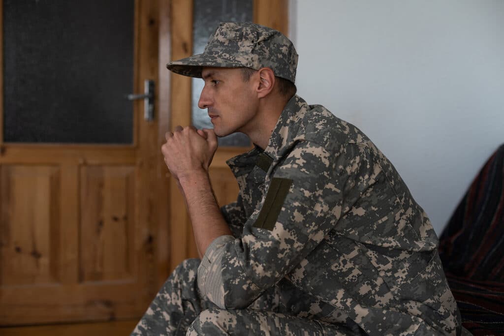 Disabled male military veteran sitting and praying.