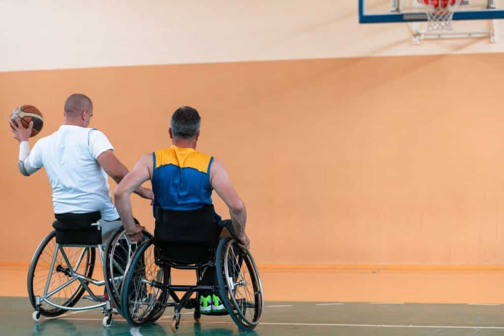 War veterans are playing basketball with a team in a modern sports arena.