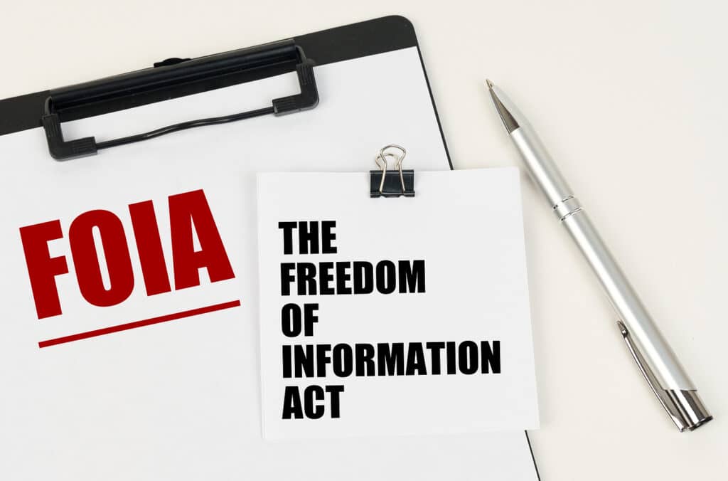On the tablet is a sheet of paper with the inscription FOIA and stickers with the inscription - THE FREEDOM OF INFORMATION ACT, next to the pen.